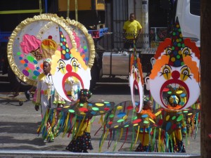 Kinder in einem Clown-Kostüm laufen bei der Grande Parade in Trinidad mit
