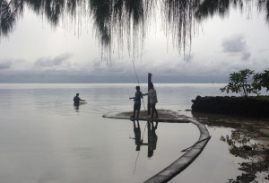 Vate und Mutter fischen mit einem Nylonnetz