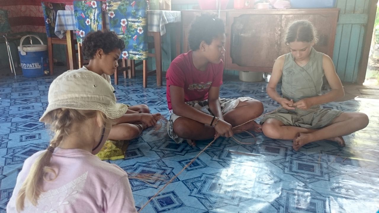 Die Kinder sind schnell dabei, der Tochter von Metui zu helfen, beim Flechten von Schnüren aus Kokosfasern.